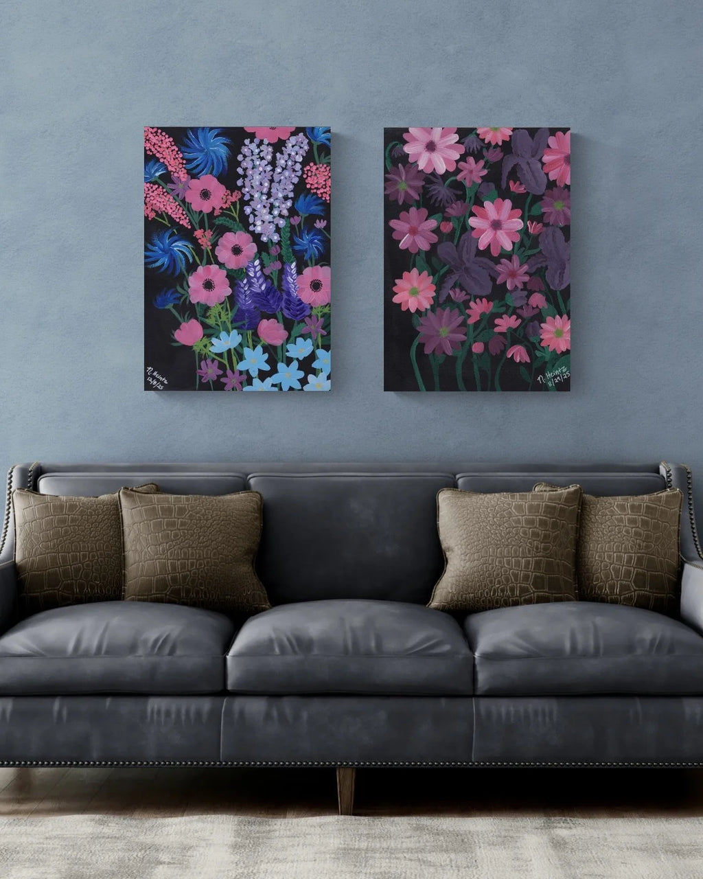 Two purple, pink, and blue floral paintings on a gray wall above a gray sofa with brown cushions.