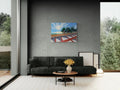 Living room with a gray sofa, coffee table, and decorative items against a gray wall with a colorful abstract painting.